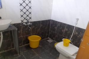 SāngliにあるSPOT ON Hotel Shree Durga Palaceのバスルーム(洗面台、トイレ、バケツ2つ付)