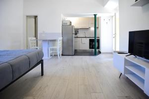 a living room with a bed and a kitchen with a television at La Casa dei Laghi 2 Comabbio Monate Maggiore Orta in Mercallo