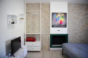 um quarto com uma cama, uma televisão e uma lareira em La Casa dei Laghi 2 Comabbio Monate Maggiore Orta em Mercallo
