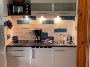 a small kitchen with a sink and a microwave at Modern Apartment in Bastorf near Sea in Bastorf