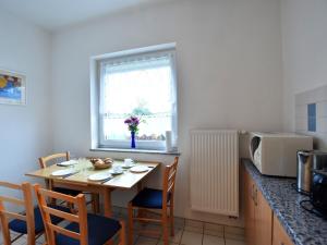 レリクにあるTasteful Apartment in Rerik Germany with Gardenの小さなキッチン(テーブル、椅子、電子レンジ付)