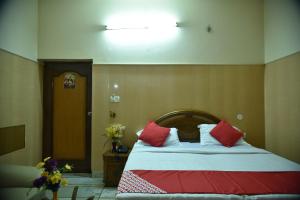 a bedroom with a bed with red and white pillows at Collection O City Heart in Hisār