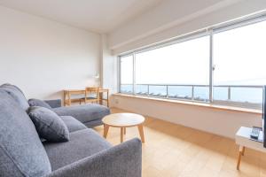 a living room with a couch and a large window at Kameya Hotel in Tsuruoka