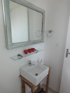 uma casa de banho com um lavatório branco e um espelho. em Villa Di Antonio em Tiradentes