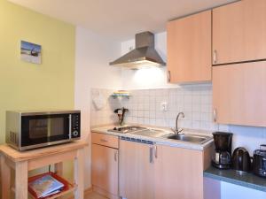 eine kleine Küche mit einer Spüle und einer Mikrowelle in der Unterkunft Modern Apartment in Elmenhorst near Sea in Elmenhorst