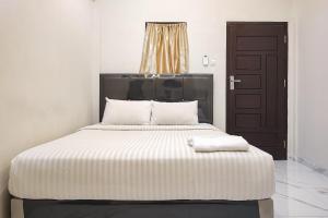 sypialnia z dużym łóżkiem z czarnymi drzwiami w obiekcie Urbanview Hotel Syariah near Jamtos w Jambi