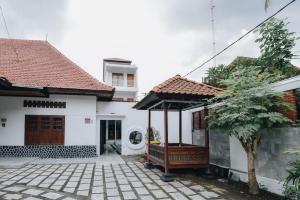 a white house with a pavilion in a courtyard at Padma Amita Yogyakarta in Jetis