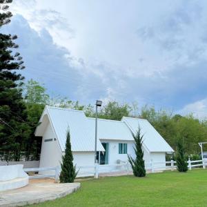 a white barn with a white fence and trees at Quality Time Farmstay: YardHouse#5 in Ban Pa Lau