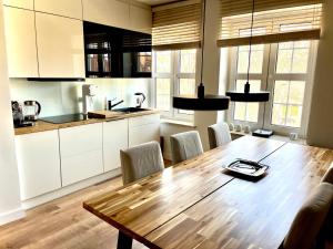 a large kitchen with a wooden table and chairs at Royal Attic Luxury Gdansk Old Town in Gdańsk