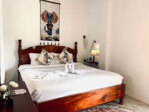 a bedroom with a bed with white sheets and a table at Vangvieng Pool House Hotel in Vang Vieng