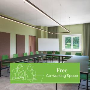 una sala de conferencias con mesa y sillas verdes en Kloster by b-smart en Schaan