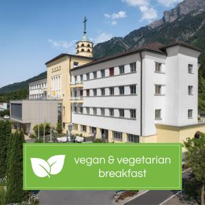沙恩的住宿－Kloster by b-smart，一座有绿色标志的建筑,上面写着素食早餐