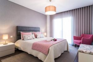 a bedroom with a bed and a pink chair at 2 bedrooms appartement with wifi at Fatima in Fátima