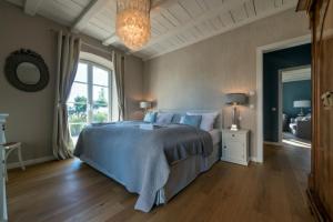 a bedroom with a large bed and a chandelier at Lerchenhof in Reestow