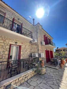 an outdoor patio with tables and chairs on a building at Hotel Esperides in Kardamyli