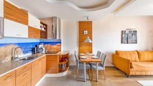 uma cozinha e sala de jantar com uma mesa e um sofá em Apartamenty Sun & Snow Melioracyjna em Karwia