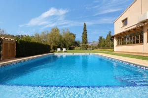 a large blue swimming pool next to a building at Villa Can Font in Palma de Mallorca