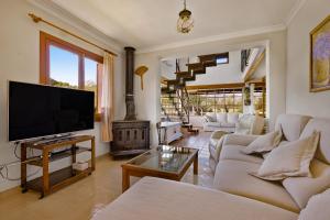 Una sala de estar con televisión y chimenea. en Villa Can Font, en Palma de Mallorca