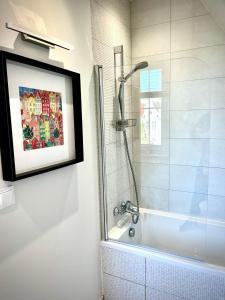 baño con ducha y una foto en la pared en Royal Attic Luxury Gdansk Old Town, en Gdansk 25 fotos más
