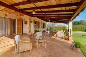 an outdoor patio with chairs and a wooden pergola at Villa Can Font in Palma de Mallorca