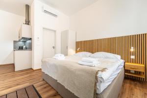 a bedroom with a large bed with towels on it at Design Apartments Lužánky in Brno