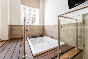 a bathroom with a tub and a window at Design Apartments Lužánky in Brno