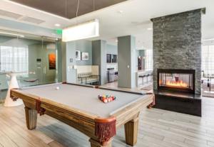 a pool table in a living room with a fireplace at Blueground E Cambridge gym wd near T stop BOS-967 in Boston