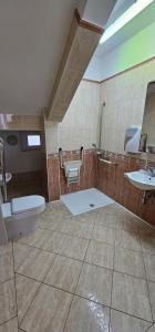 y baño con 2 lavabos, aseo y espejo. en Depandansa Vista Parco, Izola en Izola