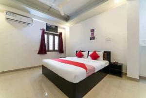 a bedroom with a large bed with red pillows at OYO HOTEL FORTUNE BLISS in Hyderabad