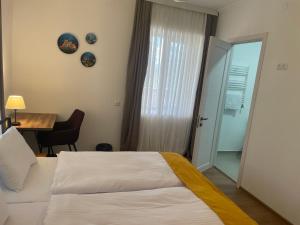 1 dormitorio con cama, mesa y escritorio en Friendly Home en Tʼelavi