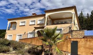a building with a palm tree in front of it at Casa Mas Ambros con piscina desbordante in Calonge