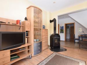 a living room with a tv and a wood stove at Cozy Apartment in Rerik near the beach in Rerik