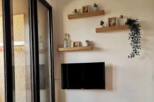 a flat screen tv hanging on a wall at Appartement à Seignosse Le Penon - 200m plage in Seignosse +10 photos