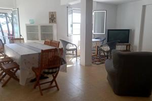sala de estar con mesa, sillas y TV en Casa pepiño sv, en San Vicente do Mar