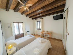 a bedroom with two beds and a table and a ceiling at Case al Borgo-Agira Centre-Home Relais in Agira
