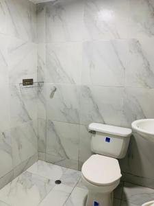 a white bathroom with a toilet and a sink at Hotel Belmar piso 2 in Cartagena de Indias