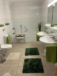 a bathroom with two sinks and a tub and two rugs at Jagdhäusl in Ramsau
