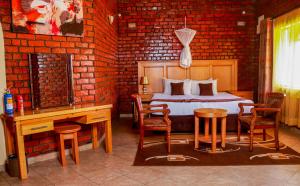Schlafzimmer mit einem Bett, einem Tisch und Stühlen in der Unterkunft Stephen Margolis Resort in Harare