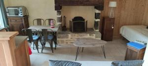 - un salon avec une cheminée, une table et des chaises dans l'établissement Talvern, Les Mouettes à Landévant, à Landévant