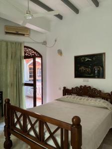 a bedroom with a bed and a large window at Village Inn Resort in Negombo