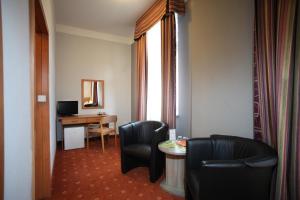 a hotel room with two chairs and a desk with a computer at Hotel Paris in Mariánské Lázně