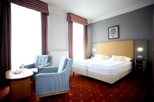 Habitación de hotel con cama y silla en Hotel Paris, en Mariánské Lázně