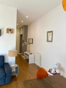 a living room with a blue couch and a table at Agrigento Flat - apartment with Private Parking in Agrigento