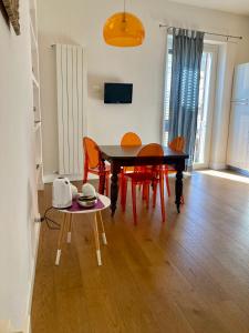 une salle à manger avec une table noire et des chaises orange dans l'établissement Agrigento Flat - apartment with Private Parking, à Agrigente