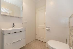 ein weißes Badezimmer mit Toilette und Waschbecken in der Unterkunft Haus Atlantik in Kühlungsborn