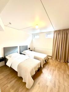 2 camas num quarto com pisos e janelas em madeira em Hotell By Bostadsagenturen em Estocolmo