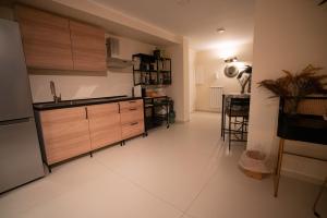 a kitchen with wooden cabinets and a white floor at Vinto House Salerno Downtown in Salerno