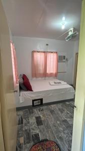 um quarto com uma cama grande e cortinas cor-de-rosa em Villa Sabang Beach Resort em Puerto Galera