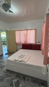 um quarto com uma cama com duas toalhas em Villa Sabang Beach Resort em Puerto Galera