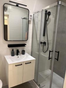 uma casa de banho com um chuveiro, um lavatório e um espelho. em Studio App Lea em Umag